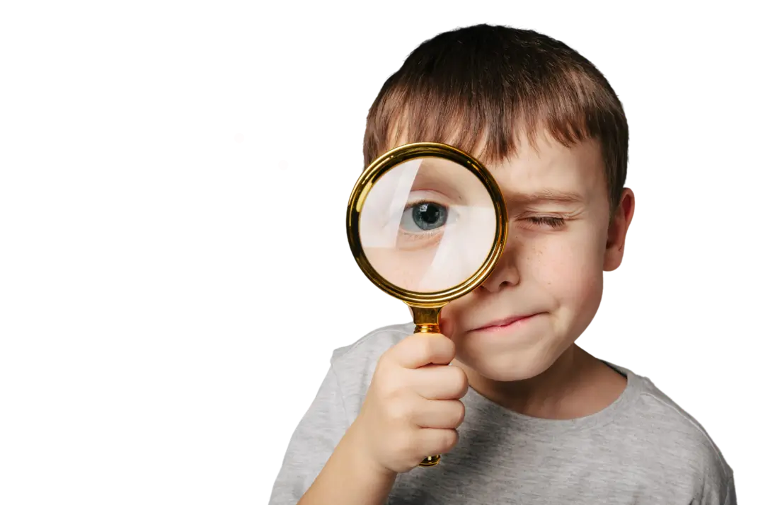Image of a boy holding a magnifying glass looking directly into the camera to represent the importance of spotting billing errors in medical bills.